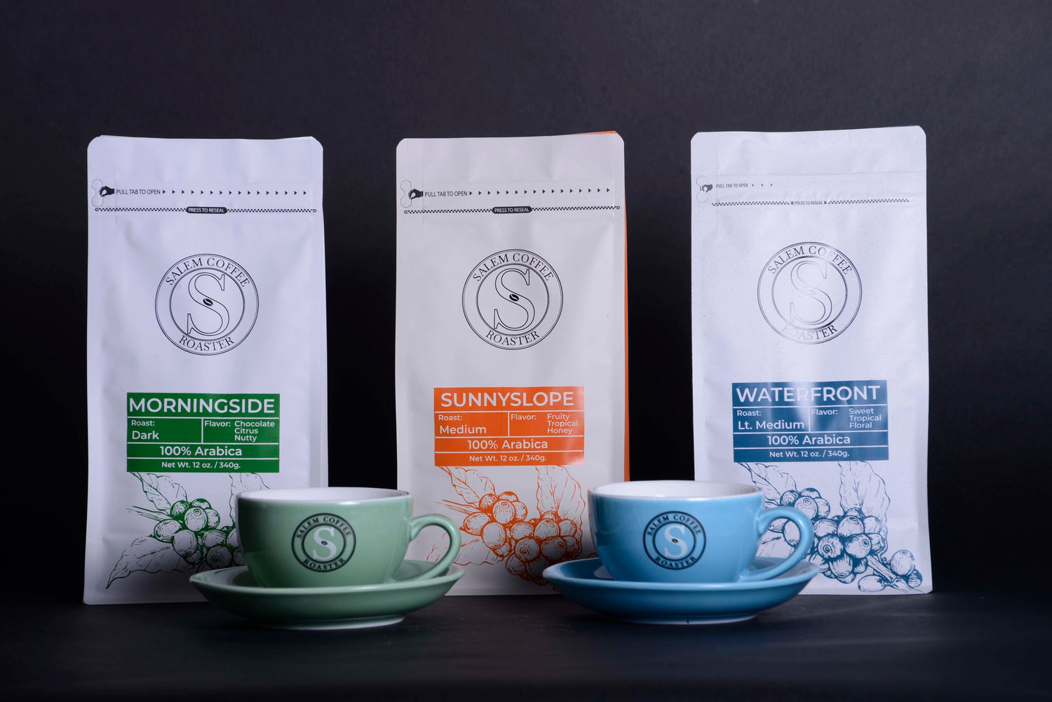 Green ceramic coffee cup Blue ceramic coffee cup Morningside Roast (Dark) 100% Arabica Specialty Coffee Roast: Dark Flavor Notes: Chocolate, Citrus, Nutty Sunnyslope Roast (medium) 100% Arabica Specialty Coffee Roast: Medium Flavor Notes: Fruity, Tropical, Honey Waterfront Roast (light/medium) 100% Arabica Specialty Coffee Roast: Light/Medium Flavor Notes: Fruity, Tropical, Honey